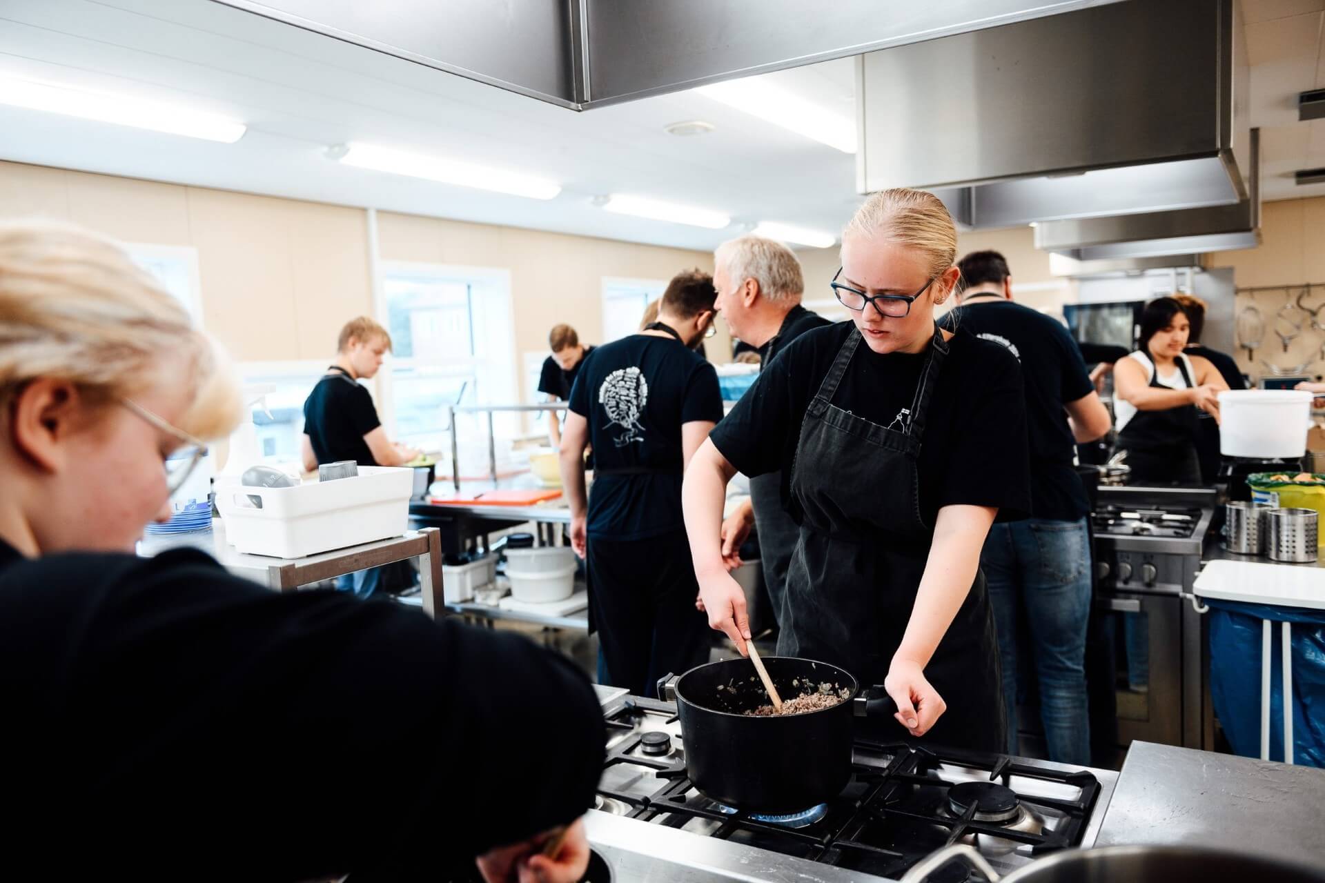 Elever sorterer grøntsager i skolens storkøkken